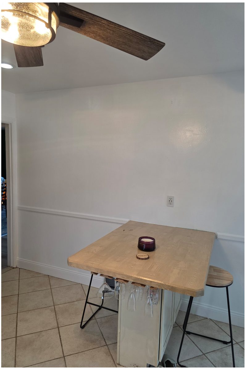 The same dining nook repainted white from ceiling line to baseboard, chair rail and trim included