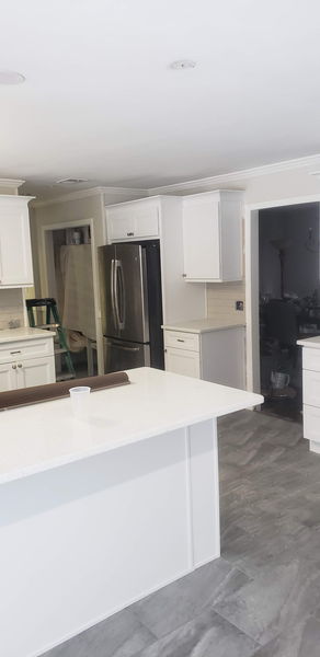 White shaker kitchen with quartz counters, subway backsplash and a stainless range