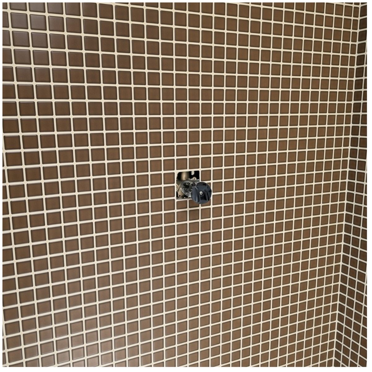 The brown mosaic tile patched back in around the new shower valve stem