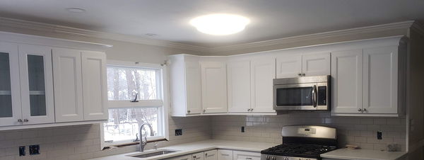 Finished kitchen with white shaker cabinets, quartz countertops and a white subway tile backsplash
