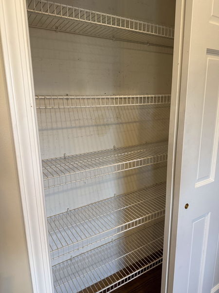 Wire closet shelving installed on several levels behind a bifold door