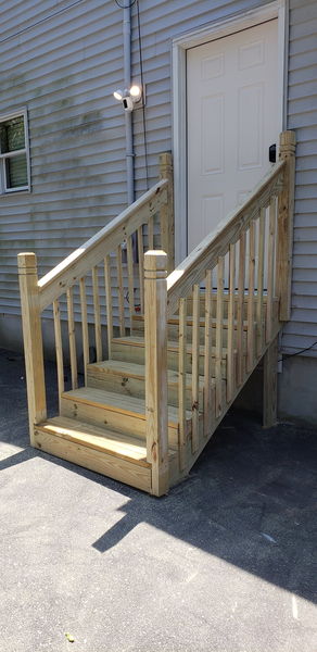 Pressure-treated stair railing with turned newel posts and even baluster spacing