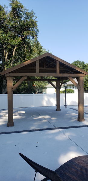 Gable end of a timber-frame pavilion showing exposed rafters and bracing