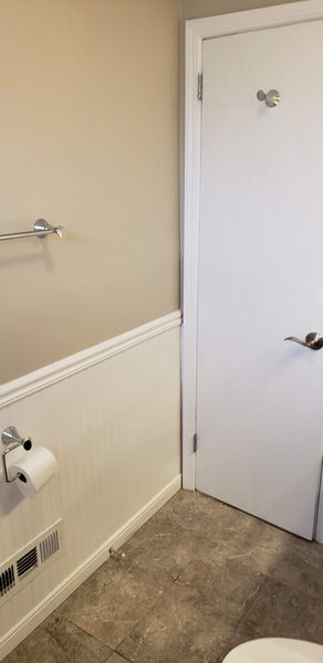 White beadboard wainscoting and chair rail installed around a bathroom wall