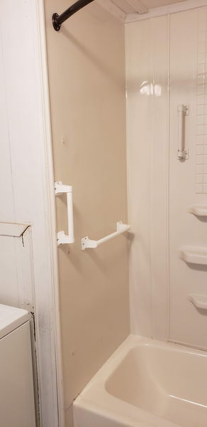 Grab bar mounted inside a one-piece tub and shower surround