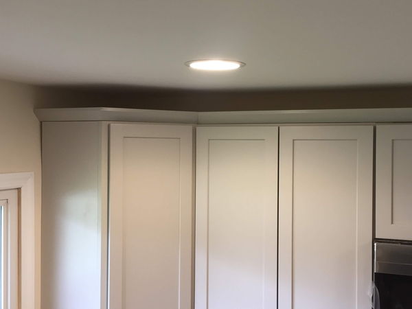White shaker wall cabinets finished with crown moulding along the ceiling
