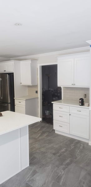 White shaker cabinets and quartz counters below a subway tile backsplash