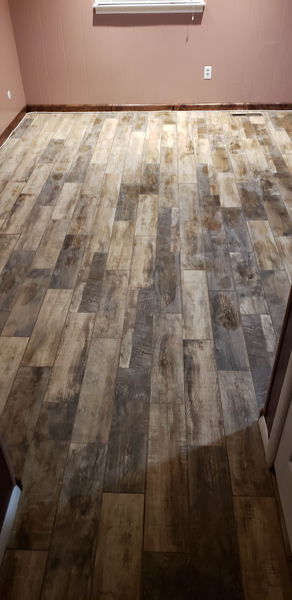 Wood-look plank tile filling a living room floor edge to edge